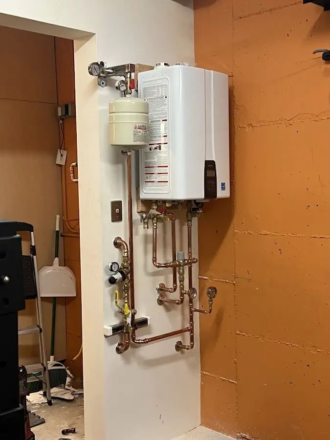 Plumbing technician inspecting water heater connections in Chehalis